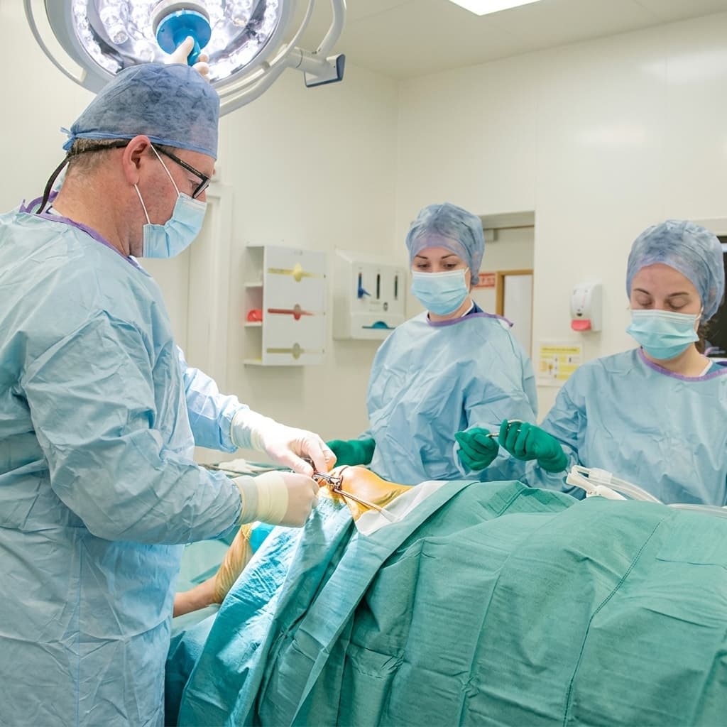 Orthopaedic surgeon and theatre team performing a knee procedure in an operating theatre